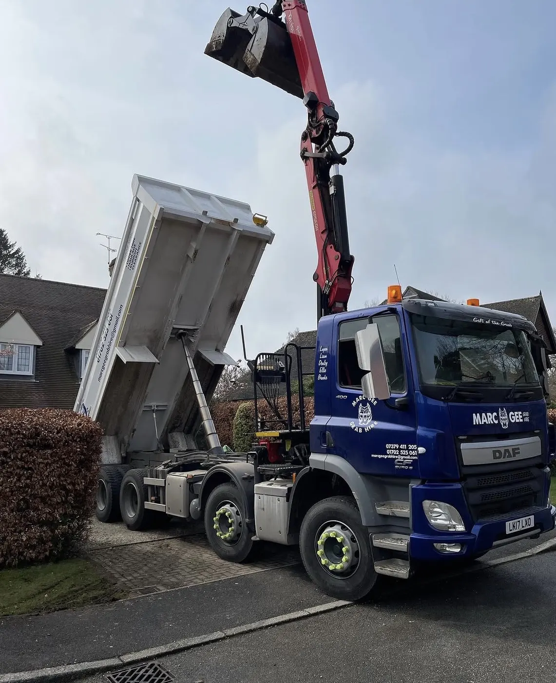 Marc Gee DAF grab lorry tipping on a residential driveway with the grab raised