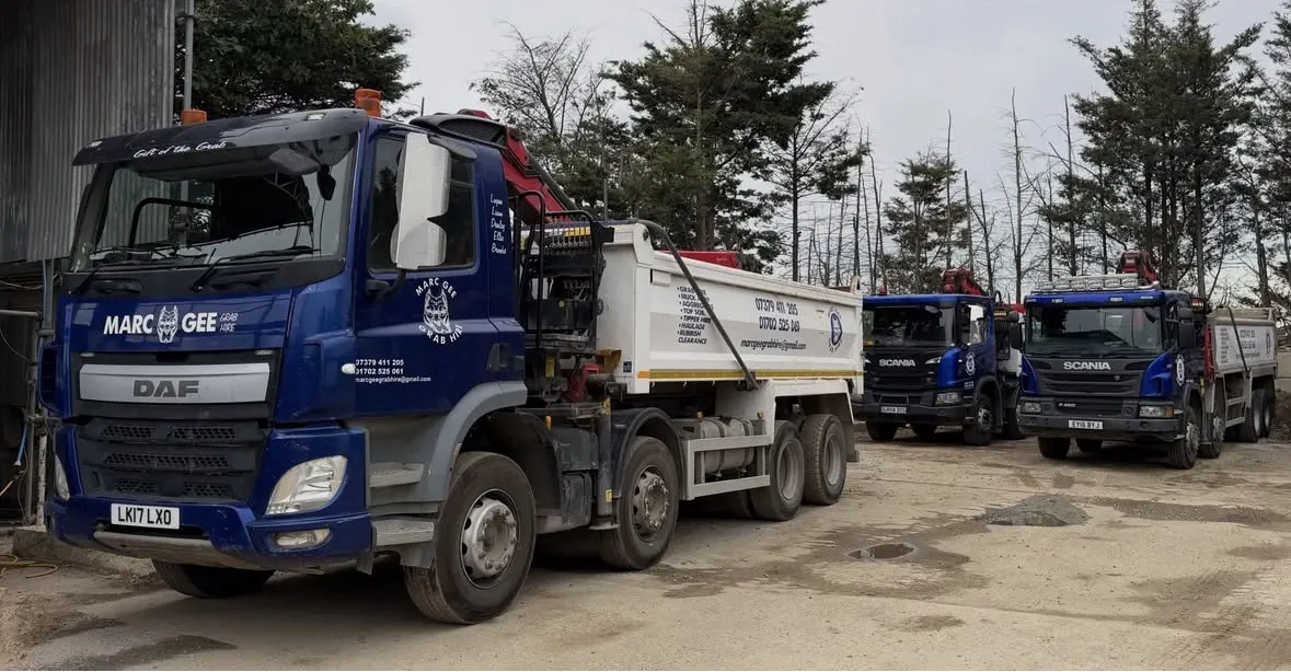 Three Marc Gee Grab Hire 8-wheel grab lorries, a DAF and two Scanias, lined up in the yard