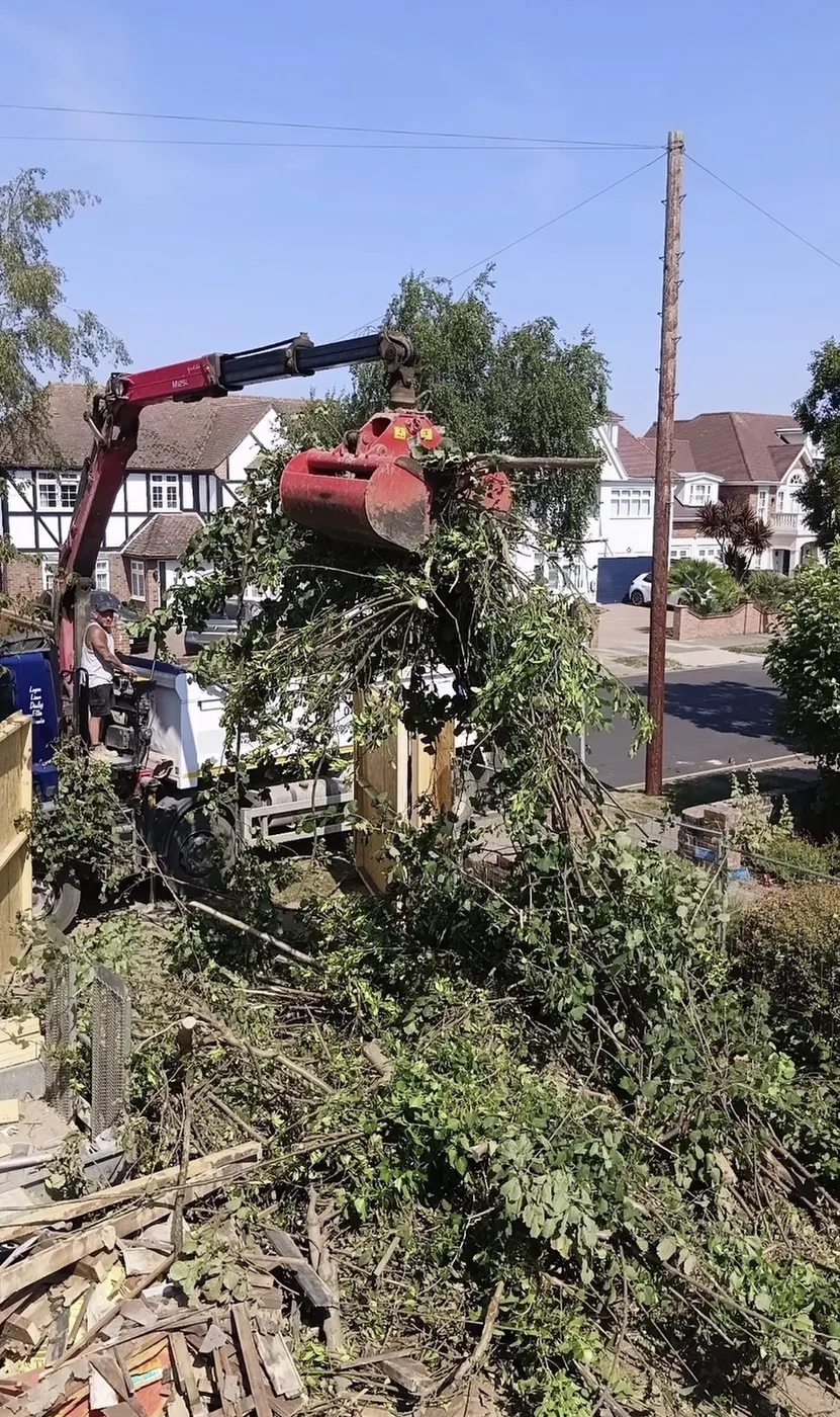 Grab loading hedge cuttings and green waste from a front garden